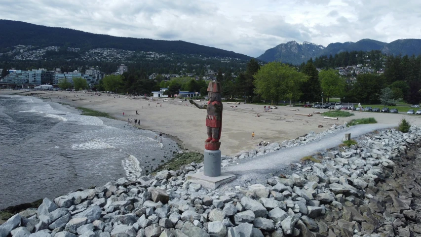 a rock strewn beach with a sculpture in the middle