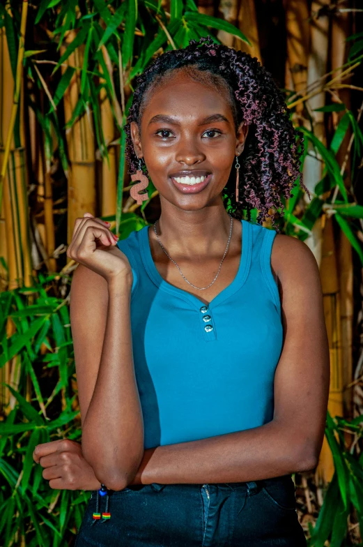 a girl is smiling for the camera in front of bamboo