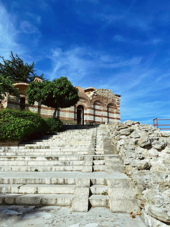 an empty stone staircase near some trees and rocks