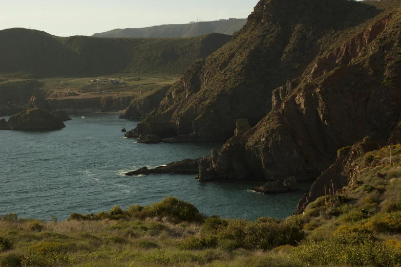 large rocks on the side of a mountain overlooking water