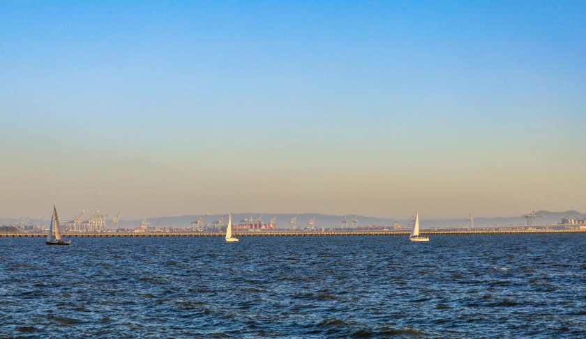 there are three boats floating on the blue water