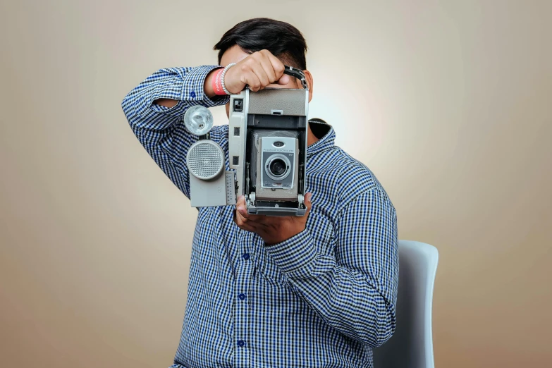 a man takes a po while holding an old camera