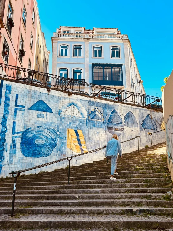 people walk down steps next to a wall that shows a large fish on it