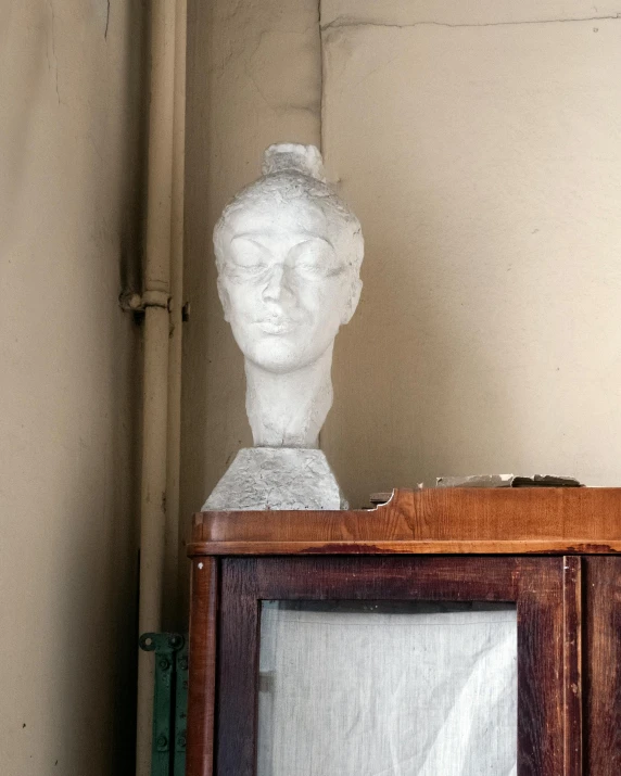 an old wooden cabinet with a white head on top of it