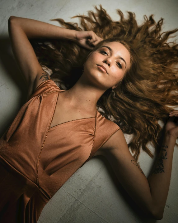 a girl with very long hair laying on the ground