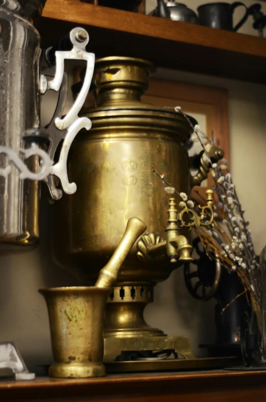 a ss container and coffee maker on top of a shelf