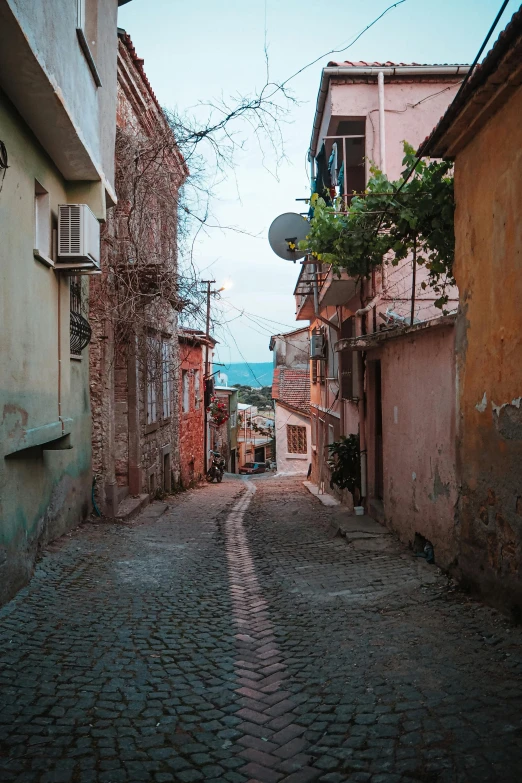 an old cobblestone street leading to a light house