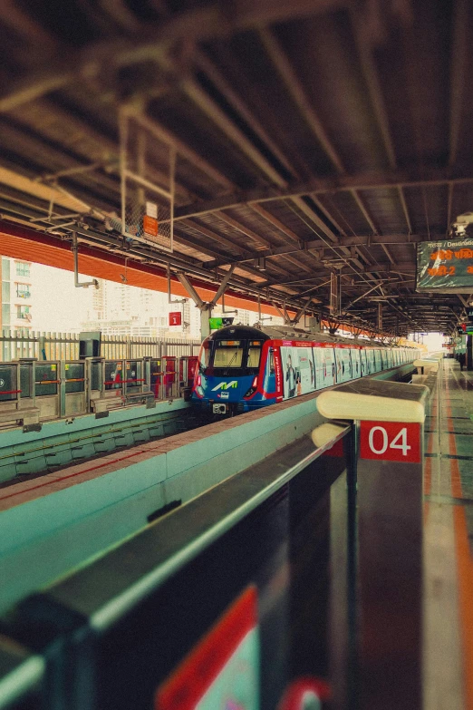 a red train on a train track in a station