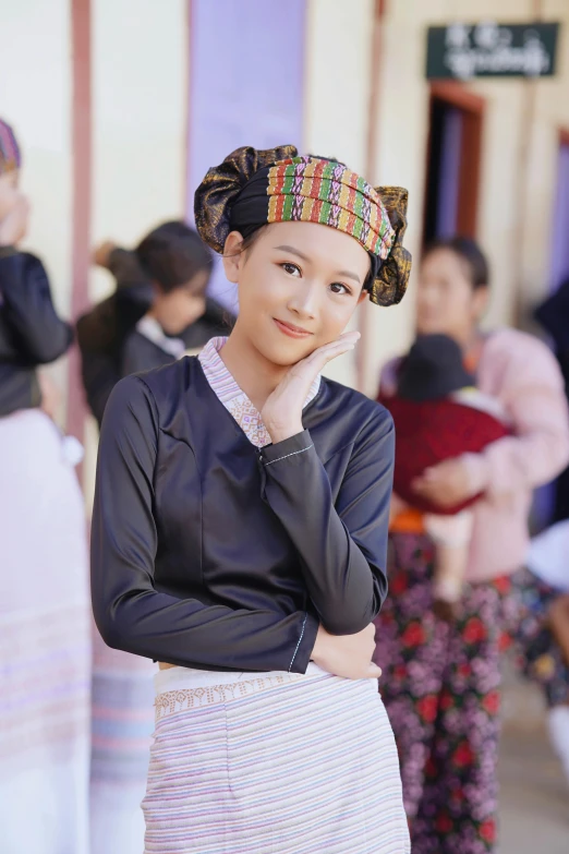 a woman with a dress and head wrap is posing for the camera