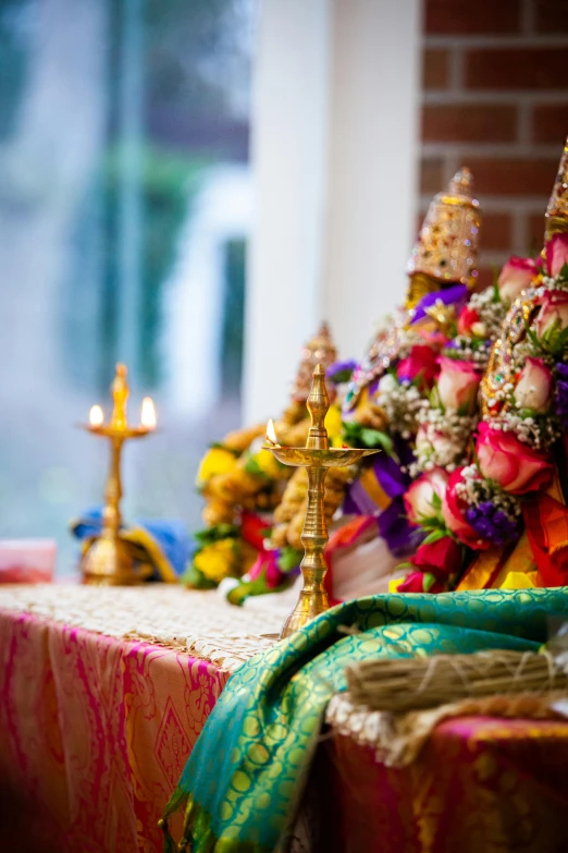 a table with three candles and several flowers