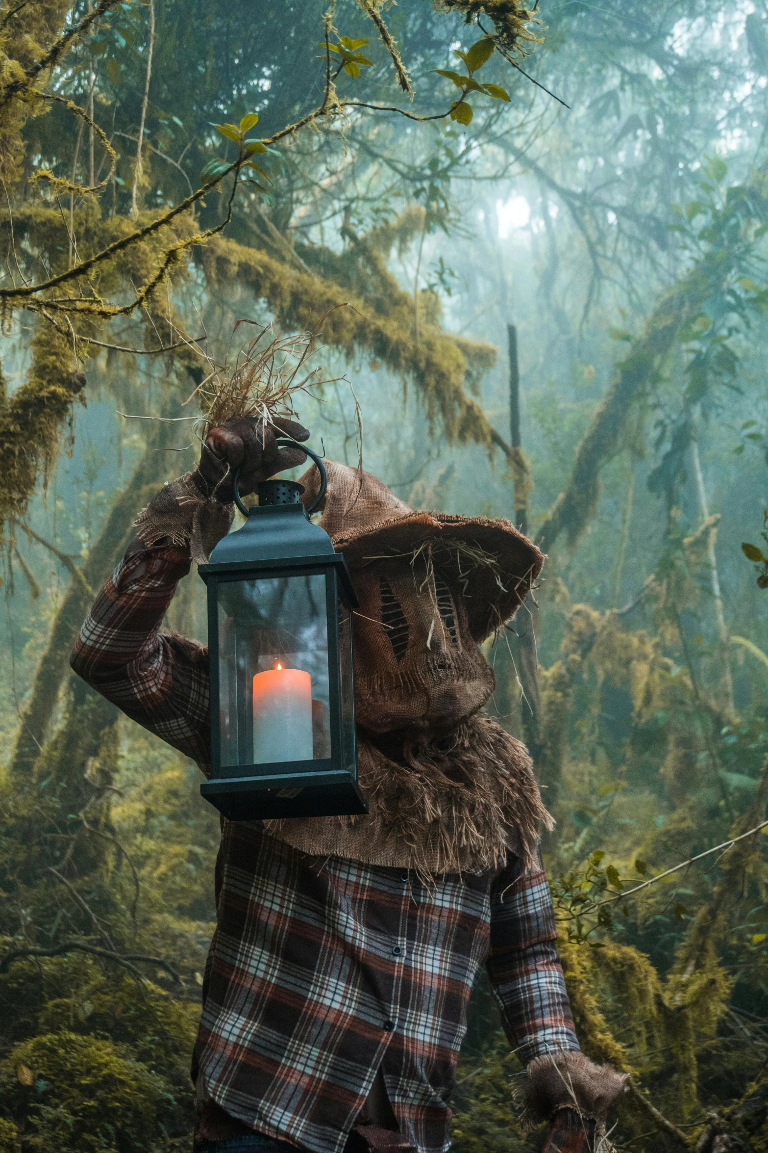 a person holding a lit candle while walking through the woods