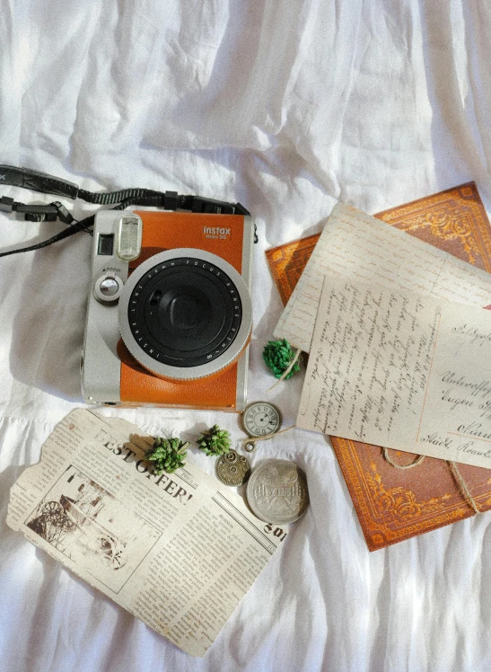 some items such as a camera, a map, and other items lying on the bed