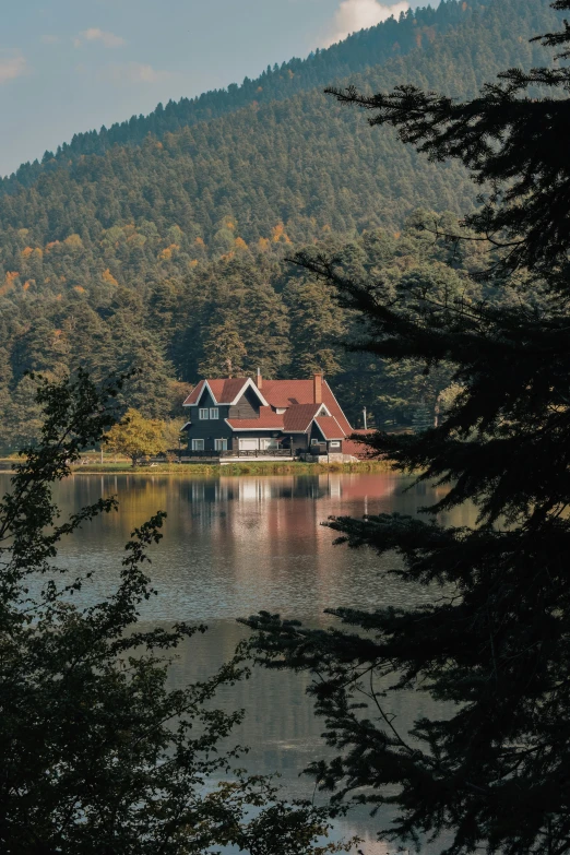 a picture of a building on a lake surrounded by trees