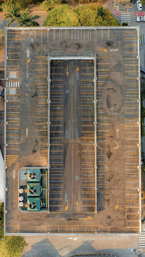 an aerial view of an empty parking lot with two trucks in the middle