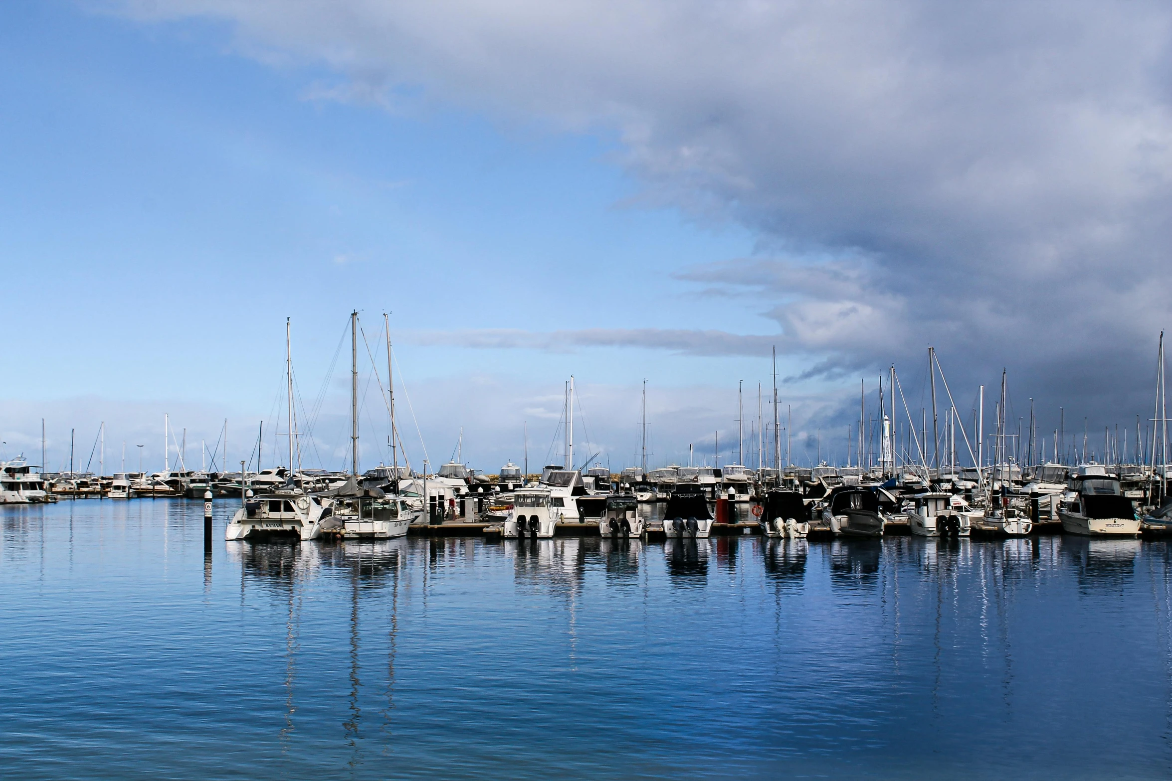 an assortment of sailboats sit in the water