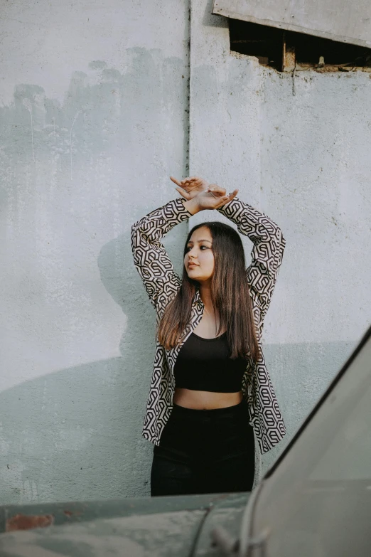 a woman posing with her hair in a bunt by a wall