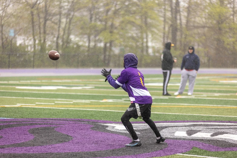 a person throwing a ball while another watches