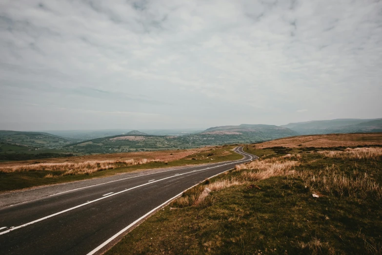 an empty road is coming up the side of a hill