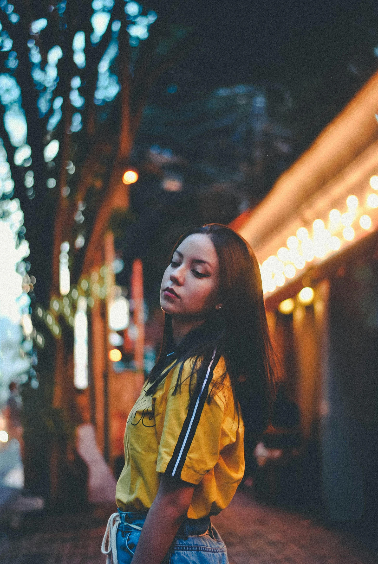 woman with long black hair posing on the side of a street