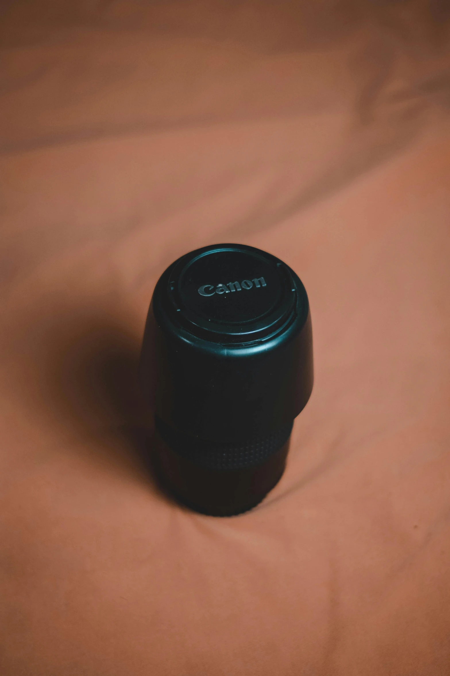 the lens cap on an camera set up on a bed