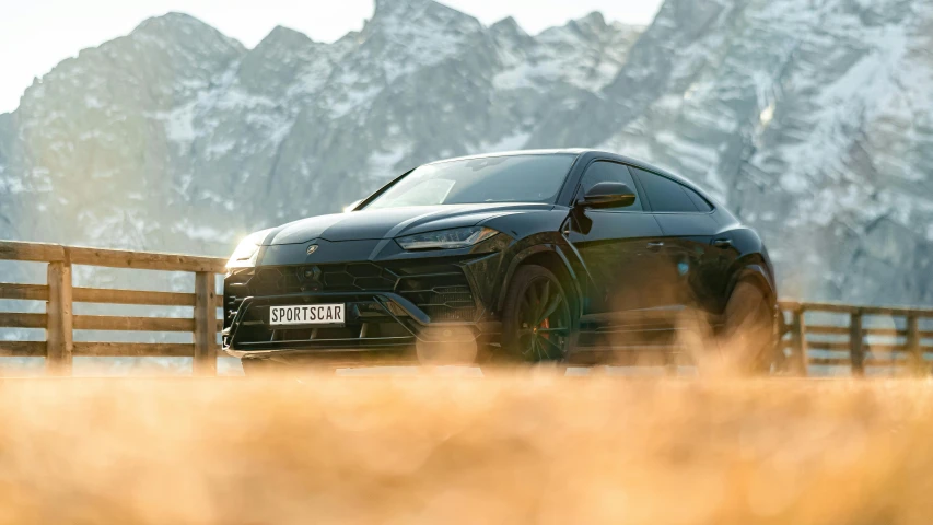 a black sports car is parked by the fence