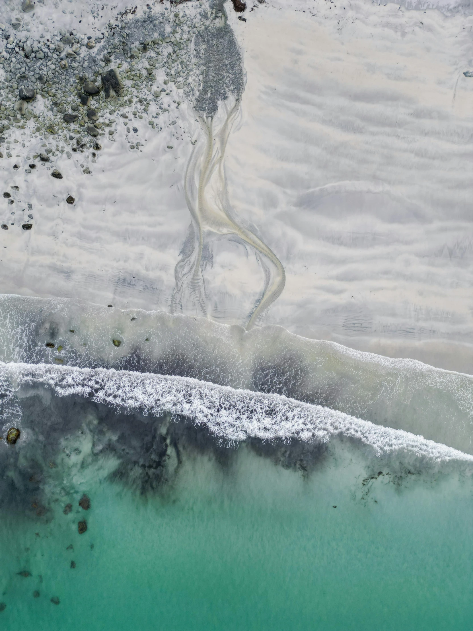 aerial pograph of water and white sand from above