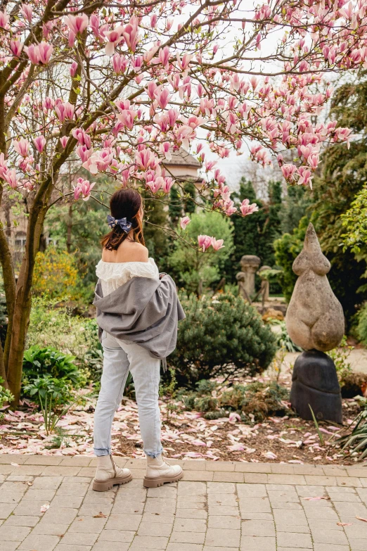 a woman standing under a flowering tree with flowers