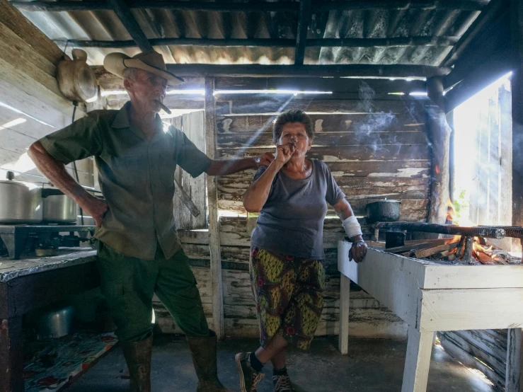 two people are cooking inside of a small kitchen