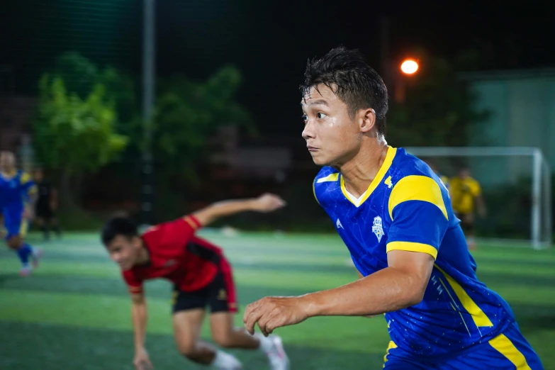 two men playing soccer on an outdoor field