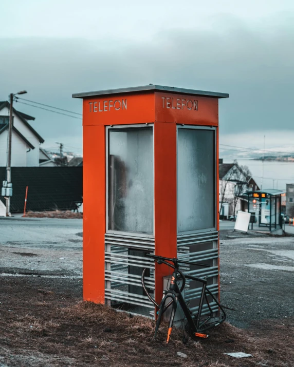 a orange portable toilet sits in the dirt