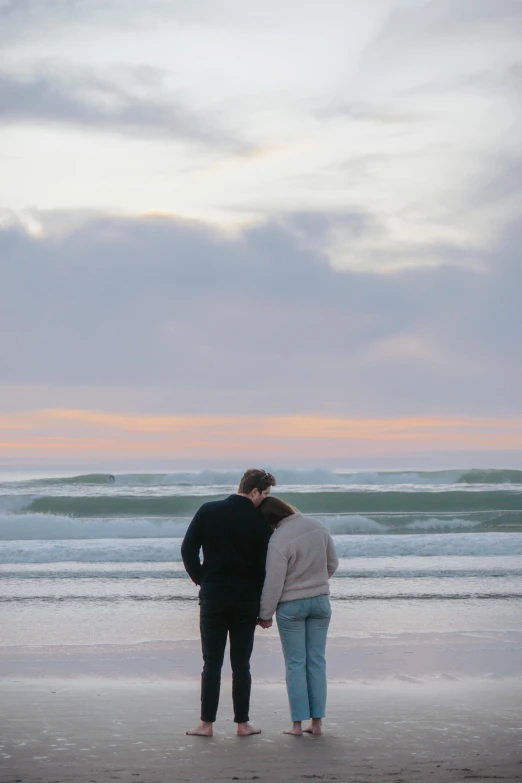 a man and a woman standing by the beach