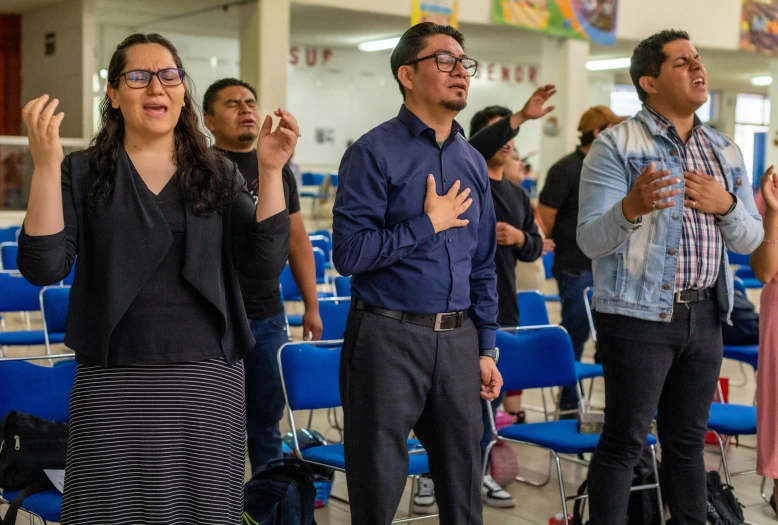 people standing and clapping while waiting in a line