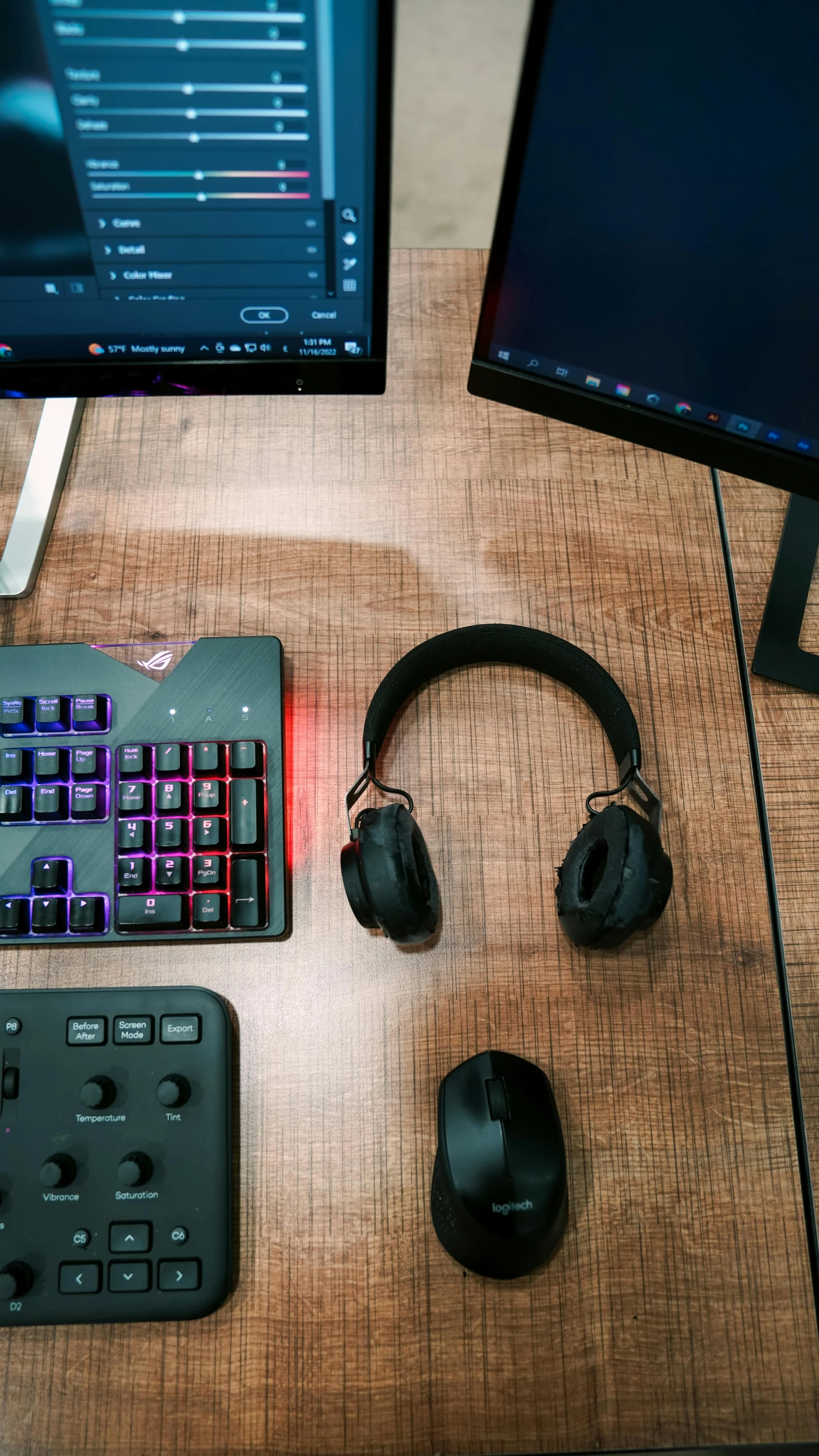 an orange and black keyboard and two computer monitors