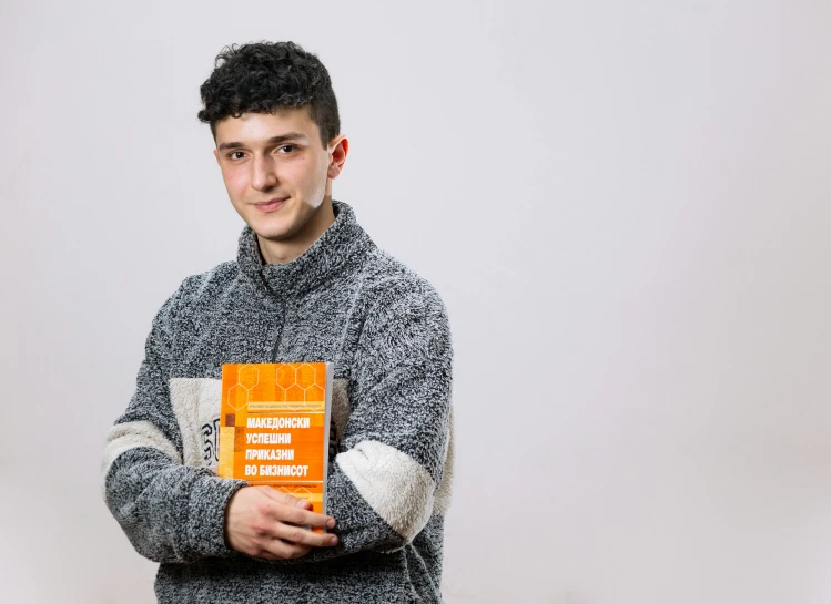 man holding a book and smiling for the camera