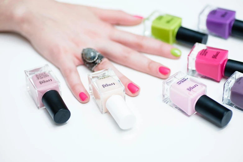 five bottles of different nail polish sitting on top of a table