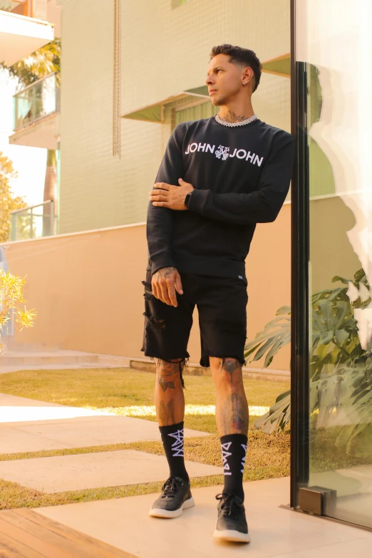 man in a sweatshirt with an arm tattoo poses for a po