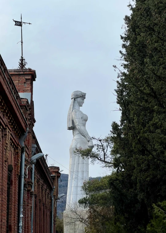 the statue of a woman with a basket is next to a building