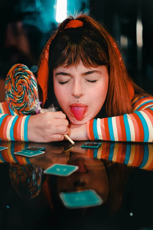 a  sticks her tongue out in front of a table