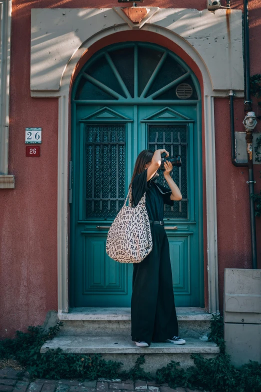 a woman standing outside of a green building