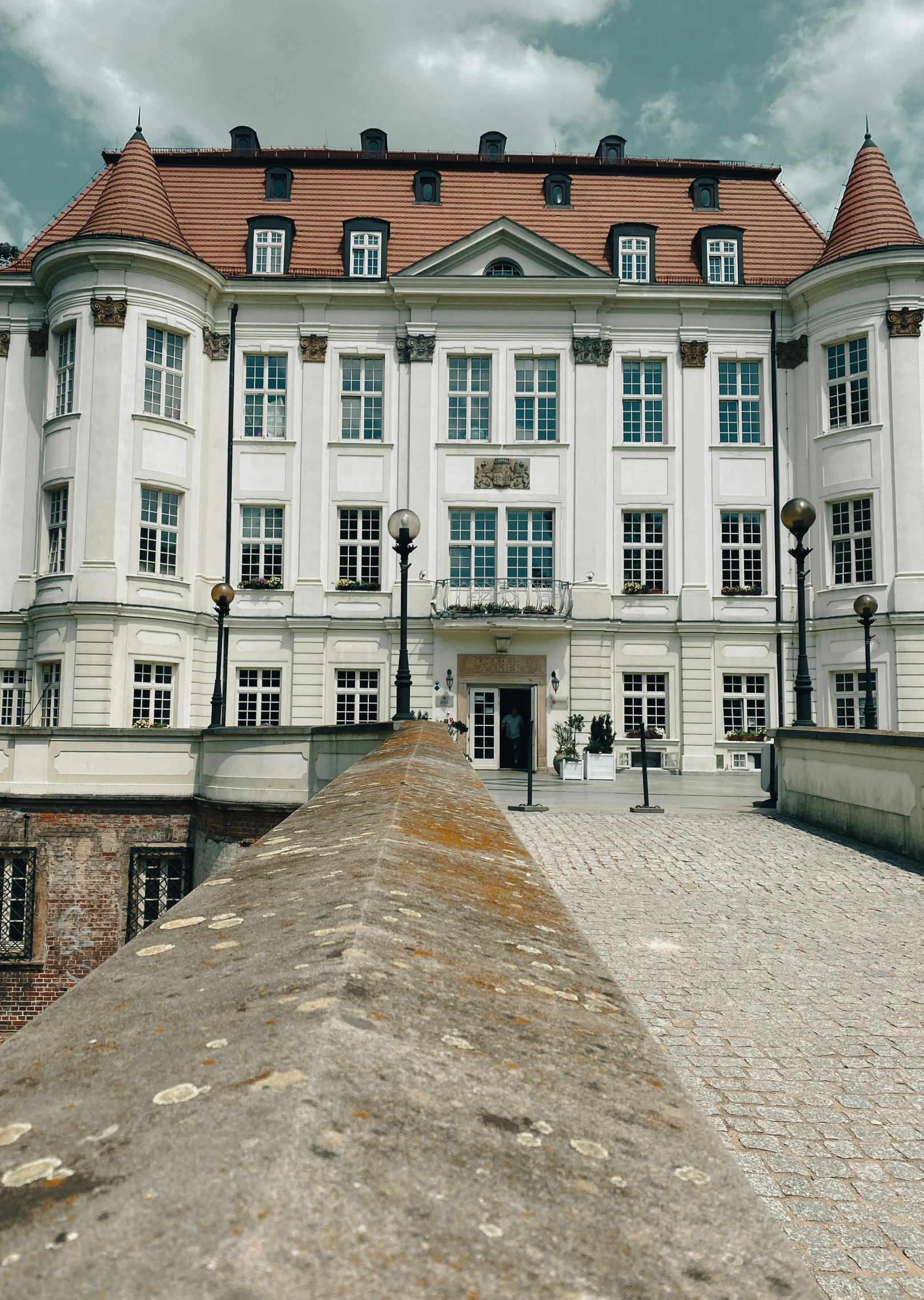 a picture of an old building with a cement walkway in front of it