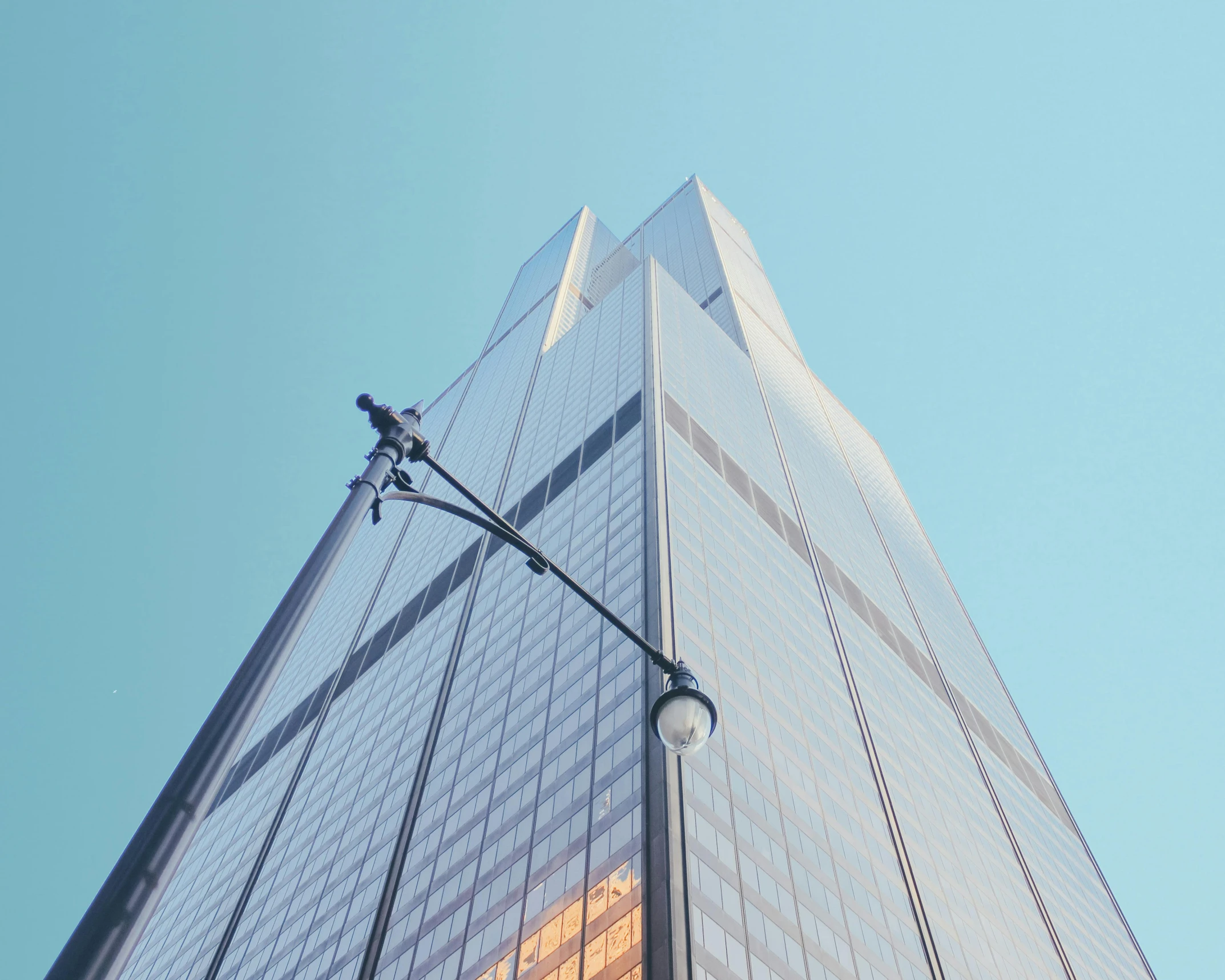 the corner of an office building is visible against a blue sky