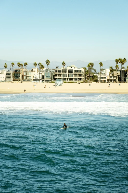 a person swimming in the water near a beach