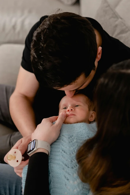 a man and woman are touching their newborn baby