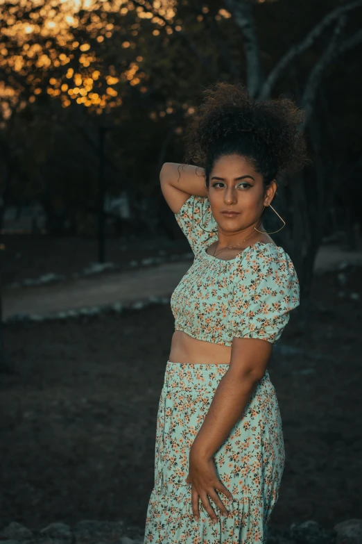 a woman in blue and floral dress posing