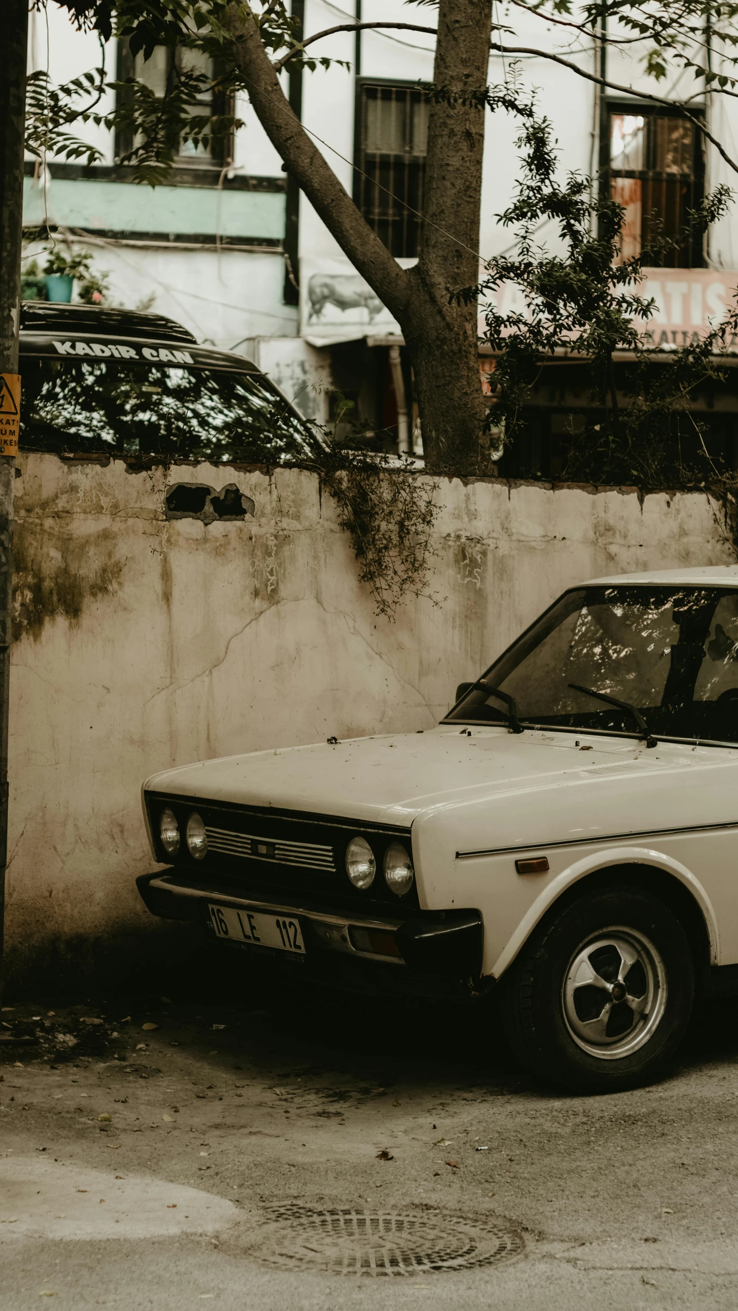 an old white car parked on the side of the road