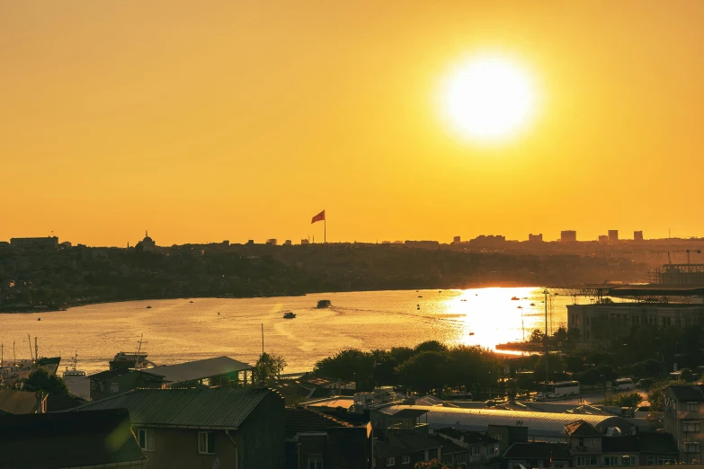 the sun is setting over the water and houses