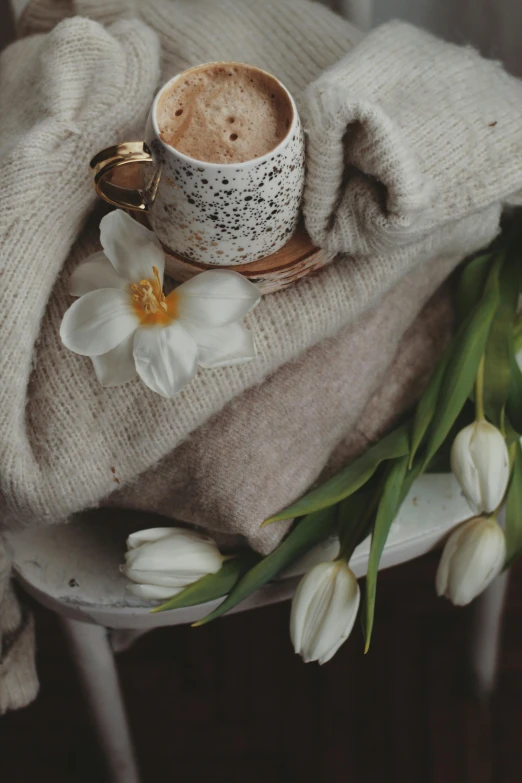 a cup and ring sitting on top of a blanket