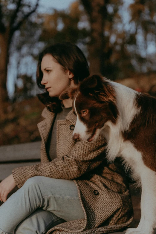 a woman is sitting on the floor with a dog on her lap