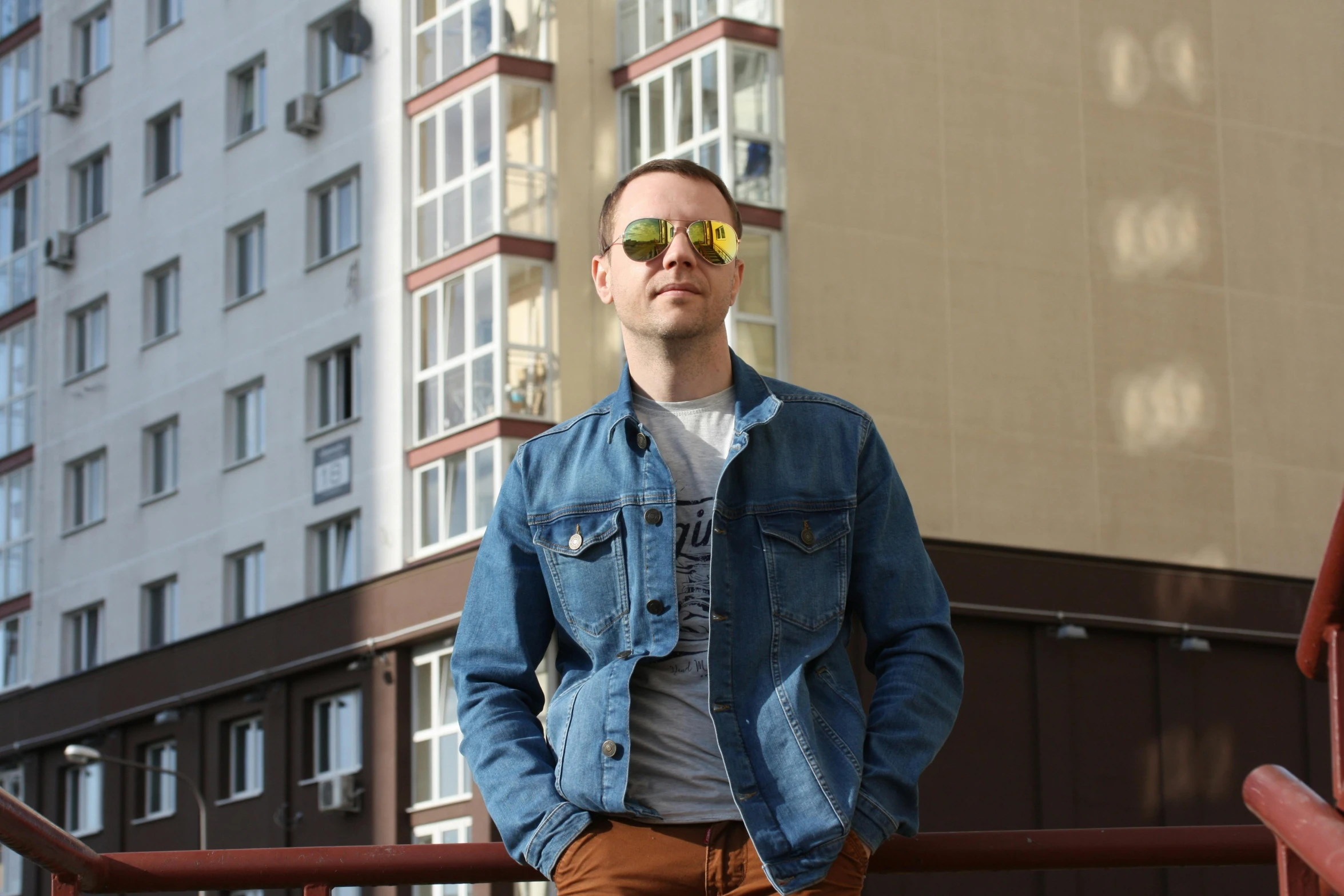 a man standing in front of some building wearing sunglasses