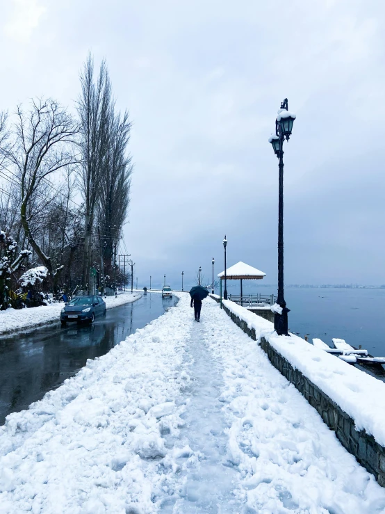 a pathway with a person walking in the snow